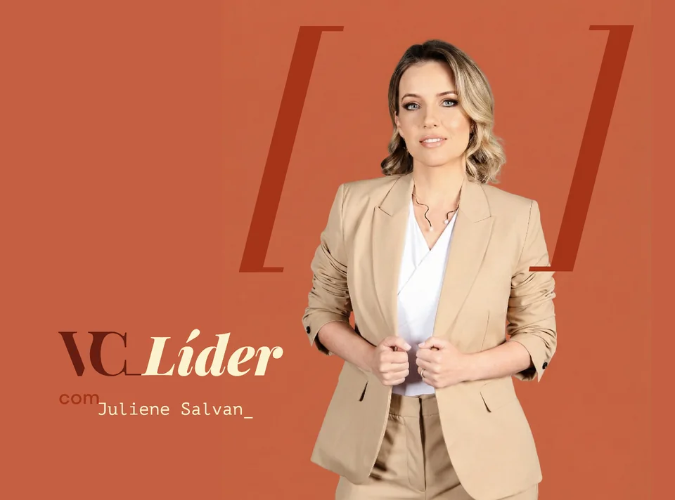 Juliene Salvan, diretora de RH e mentora de líderes, em retrato de corpo inteiro com blazer bege e fundo laranja